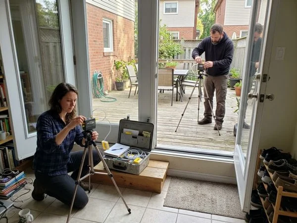 Two technicians setting up indoor and outdoor air sampling pumps for verification